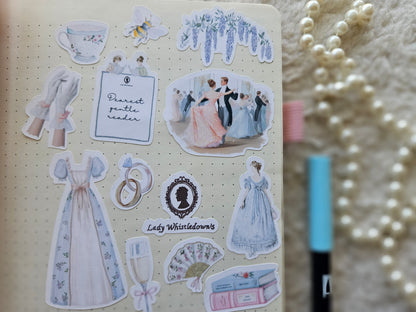 Sticker sheet with vintage-themed designs on a notebook with a pearl necklace in the background.