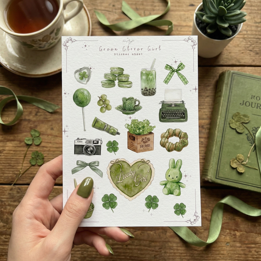Green Clover Girl Sticker Sheet by Poetry Studio. A 7x5 inch planner sticker sheet featuring hand-drawn watercolor illustrations in sage green. Stickers include a vintage typewriter, film camera, matcha latte, macarons, green bunny, and a 'Lucky Girl' heart cake. Perfect for St. Patrick's Day journaling