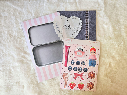 Small tin case with a decorative cover on a textured surface