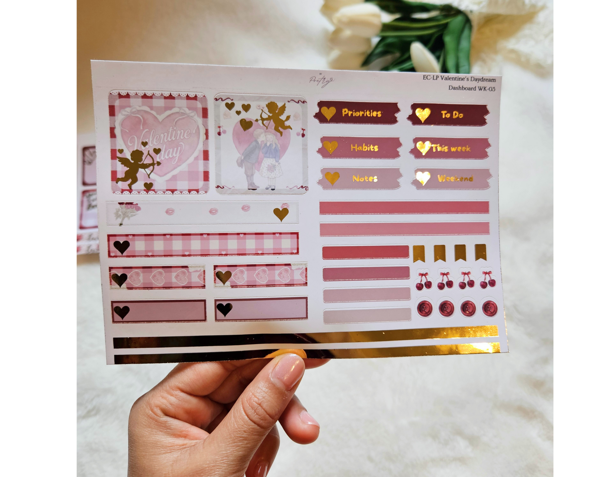 Sheet of decorative planner stickers held by a hand with a soft background