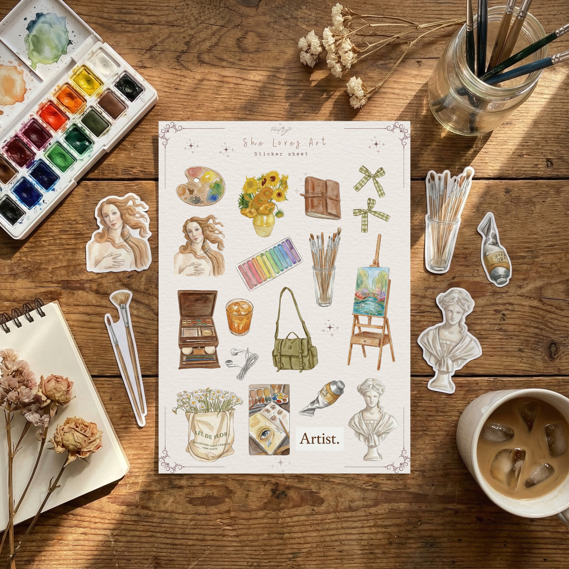 Sheet of stickers with artistic designs on a wooden table with art supplies.